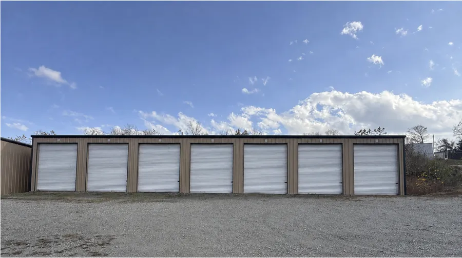 Wide gravel drive in front of roll-up storage doors in Gamaliel, AR