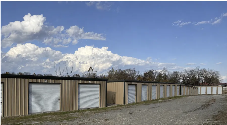 Drive-up storage unit doors along the gravel aisle in Gamaliel, AR